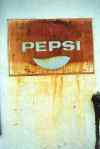 rusty pepsi-cola sign on an old fridge         