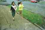 two girls running on the sidewalk in Auckland  